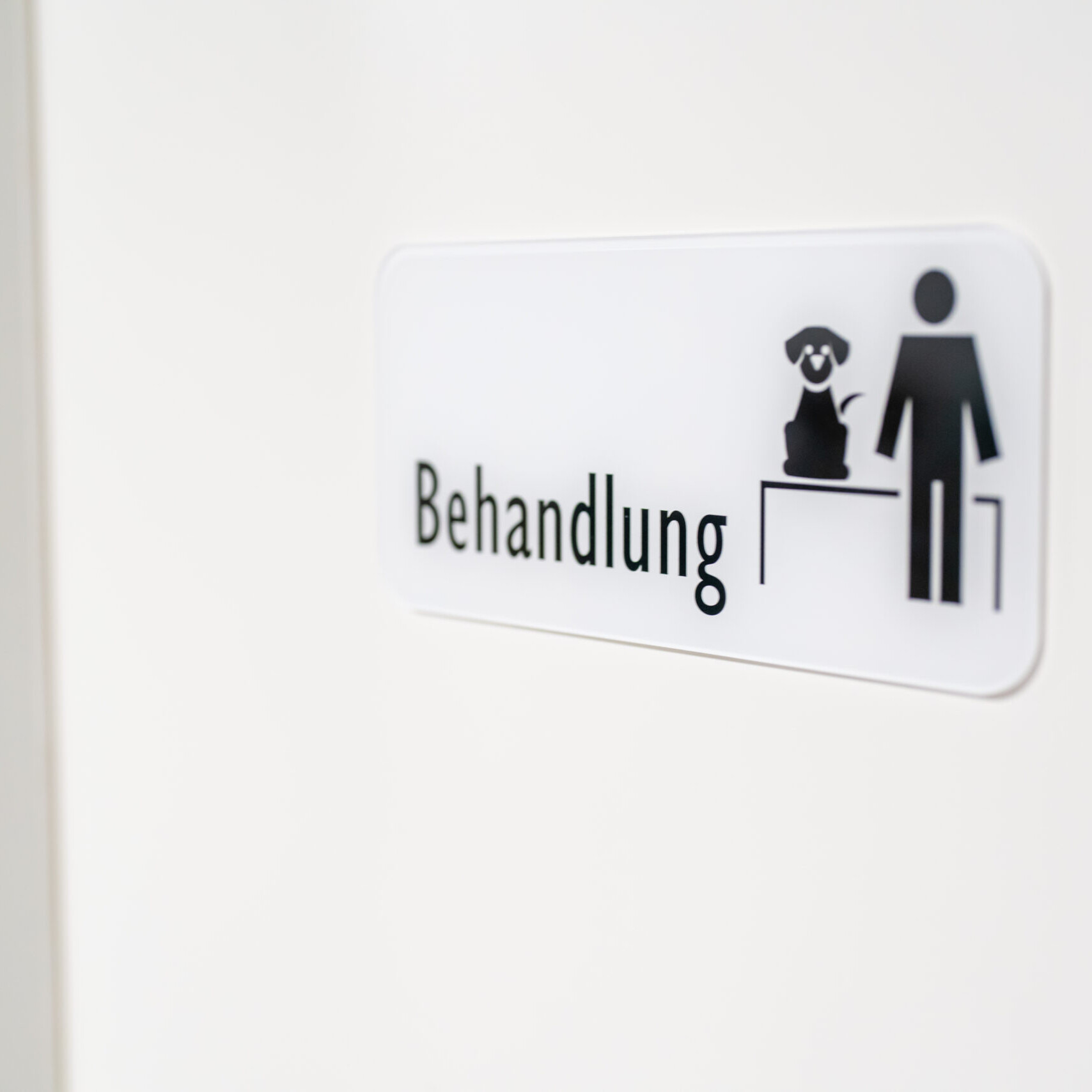 Nahaufnahme des Schildes des Behandlungsraumes